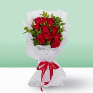 A bouquet of vibrant red roses tied with a matching red ribbon, elegantly arranged for a special occasion.