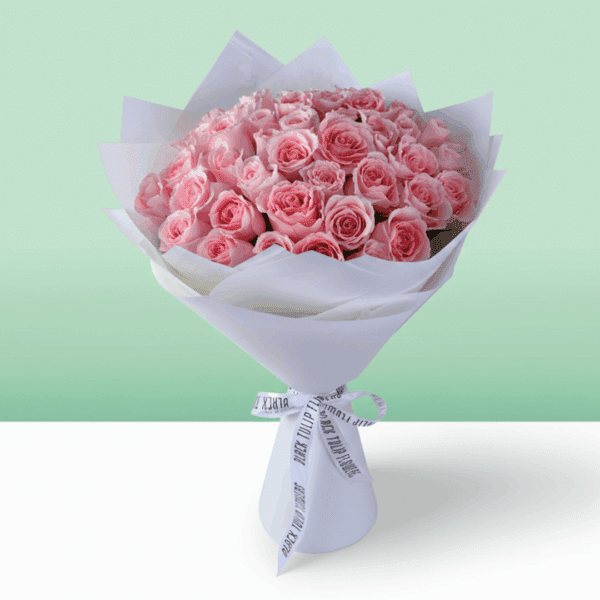Hand-tied rose bouquet wrapped in non-woven paper with a small message card attached, styled as a Mother’s Day floral gift