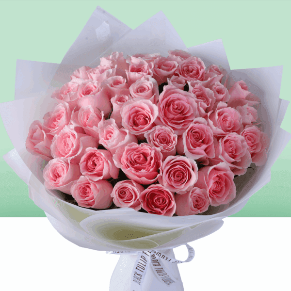 Hand-tied rose bouquet wrapped in non-woven paper with a small message card attached, styled as a Mother’s Day floral gift