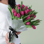 Hand-tied bouquet of 30 pink tulips in Korean-style wrapping sheets in white and tied with black satin ribbon