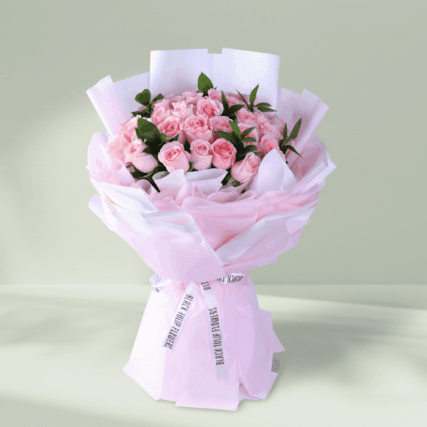 Floral arrangement of roses and spray roses in non-woven wrap with a message card styled for Mother’s Day gifting