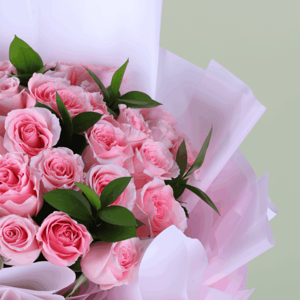 Floral arrangement of roses and spray roses in non-woven wrap with a message card styled for Mother’s Day gifting