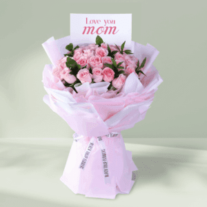 Floral arrangement of roses and spray roses in non-woven wrap with a message card styled for Mother’s Day gifting