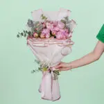Luxury bouquet of 20 blooming pink peonies and green foliage beautifully hand-tied and presented in elegant Korean-style white wrapping paper.