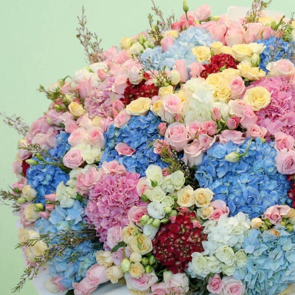 Premium pastel flower bouquet with hydrangeas, roses, eustomas, and wax flowers in a luxurious floral arrangement.