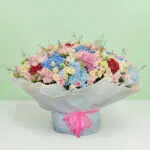 Premium pastel flower bouquet with hydrangeas, roses, eustomas, and wax flowers in a luxurious floral arrangement.