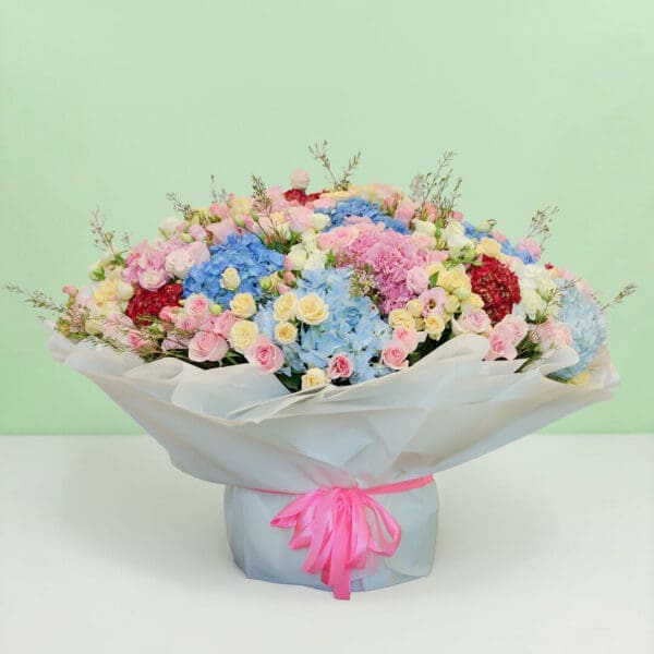 Premium pastel flower bouquet with hydrangeas, roses, eustomas, and wax flowers in a luxurious floral arrangement.