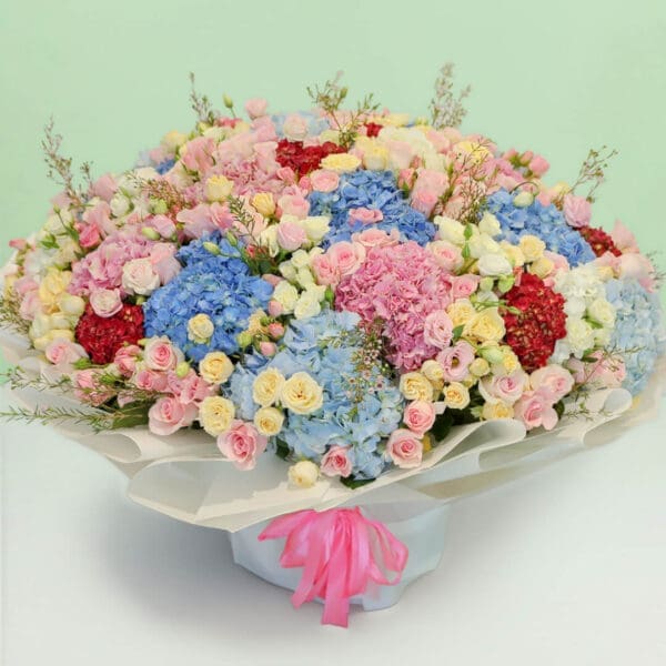 Premium pastel flower bouquet with hydrangeas, roses, eustomas, and wax flowers in a luxurious floral arrangement.