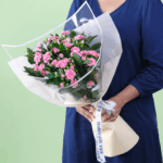 Beautifully hand-crafted 20 stem red carnation bouquet layered with fresh green leaves and wrapped in non woven paper.
