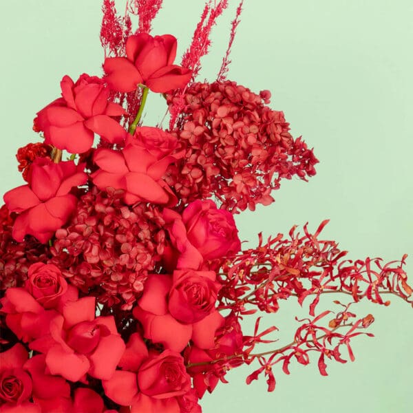 Luxurious red floral creation with high-quality fresh blooms & dried elements artistically arranged in an elegant white round gift box