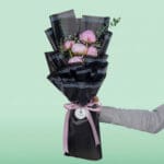 The arrangement features 5 fresh pink peony stems beautifully arranged and wrapped in premium Korean-style flower wrapping black sheets.