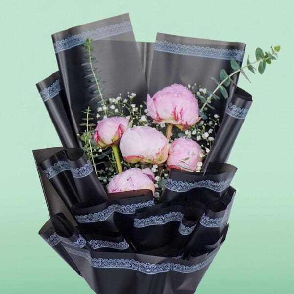The arrangement features 5 fresh pink peony stems beautifully arranged and wrapped in premium Korean-style flower wrapping black sheets.