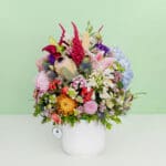 The arrangement featuring 35–40 stems of protea, hydrangea, amaranthus, pincushion, lilies, and assorted exotic flowers put together in a premium ceramic vase.