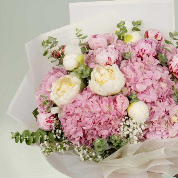 15-stem pink flower bouquet featuring peonies, hydrangeas, and fresh eucalyptus elegantly wrapped in Korean-style white wrapping sheets.