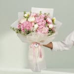15-stem pink flower bouquet featuring peonies, hydrangeas, and fresh eucalyptus elegantly wrapped in Korean-style white wrapping sheets.