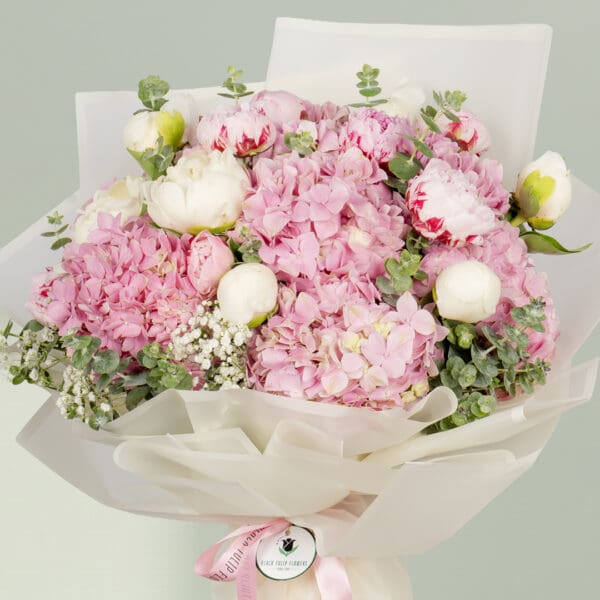 15-stem pink flower bouquet featuring peonies, hydrangeas, and fresh eucalyptus elegantly wrapped in Korean-style white wrapping sheets.